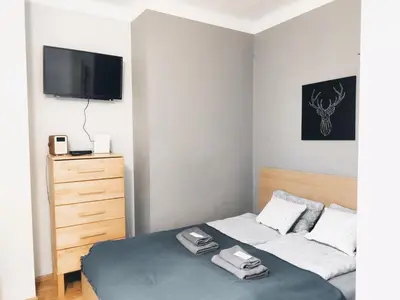 a bedroom with a bed and a dresser with a tv at Daszyńskiego 7 by Homeprime in Kraków