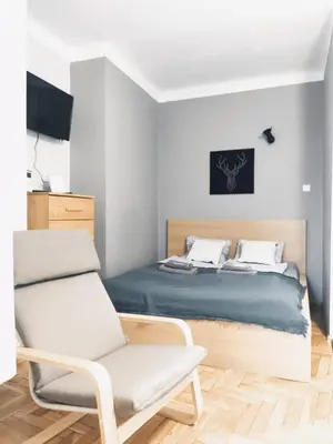 a bedroom with a bed and a chair at Daszyńskiego 7 by Homeprime in Kraków