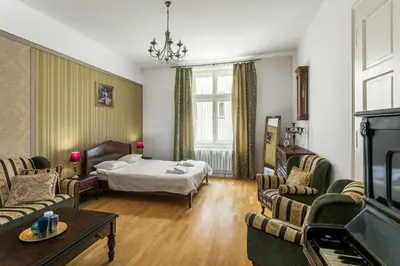 a living room with a bed and a couch and chairs at The Spiski Palace Apartments in Kraków
