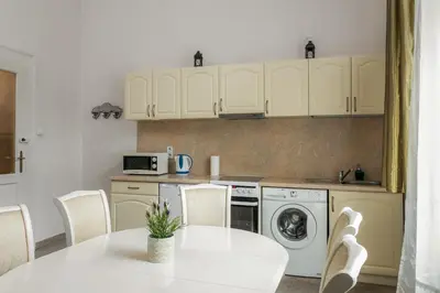 a kitchen with a white table and a white washing machine at The Spiski Palace Apartments in Kraków