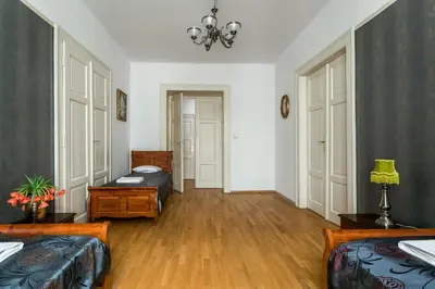 a living room with two beds and a chandelier at The Spiski Palace Apartments in Kraków