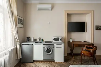 a kitchen with a washing machine and a table at The Spiski Palace Apartments in Kraków