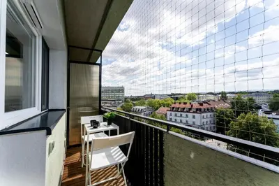 a balcony with two chairs and a view of a city at Czarnowiejska Mini Studio with loggia in Kraków