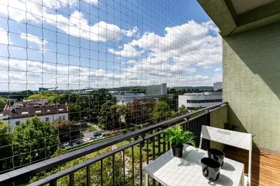 a balcony with a table and a view of a city at Czarnowiejska Mini Studio with loggia in Kraków