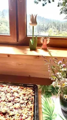 a pizza sitting on a window sill in front of a window at Urokliwy drewniany dom z widokiem na Tatry in Tokarnia