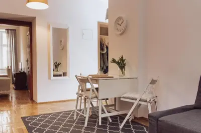 a kitchen and living room with a table and chairs at Kraków Old Town - Kazimierz Dajwór in Kraków