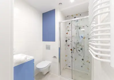 a white bathroom with a toilet and a shower at Apartamenty Meiera in Kraków