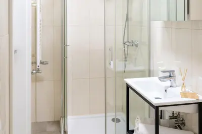 a bathroom with a sink and a shower at Happy House Apartamenty in Kraków