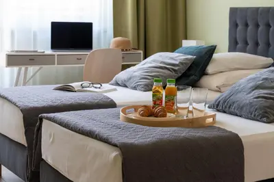 two beds with a tray of food and drinks on them at Happy House Apartamenty in Kraków