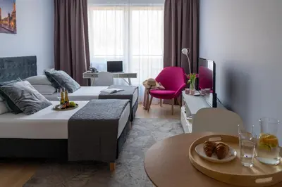 a hotel room with two beds and a table with food at Happy House Apartamenty in Kraków
