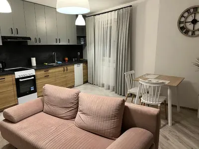 a living room and kitchen with a couch and a table at Apartament Zlota Jesień 2C in Kraków