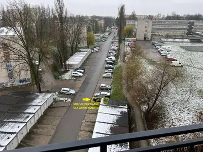 a city street with cars parked next to a river at Apartament Zlota Jesień 2C in Kraków