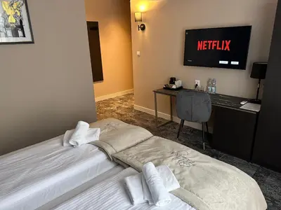 a hotel room with a bed and a desk and a television at 4Wings Apartments in Kraków