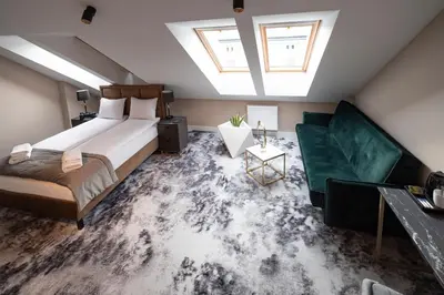 a bedroom with a large bed and a couch at 4Wings Apartments in Kraków
