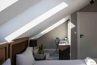 a attic room with a bed and a desk at 4Wings Apartments in Kraków
