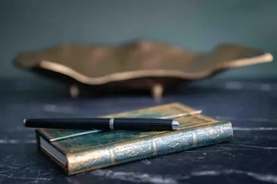 two books sitting on a table with a pen on top at 4Wings Apartments in Kraków