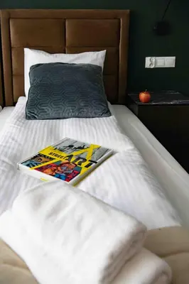 a magazine sitting on top of a bed at 4Wings Apartments in Kraków