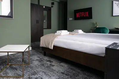 a bedroom with a large bed and a table at 4Wings Apartments in Kraków