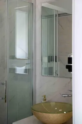 a bathroom with a sink and a glass shower at 4Wings Apartments in Kraków