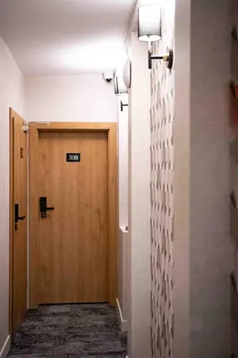 a hallway with a door with a sign on it at 4Wings Apartments in Kraków