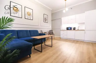 a living room with a blue couch and a table at Elegancki apartament w centrum miasta-Kazimierz in Kraków