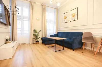 a living room with a blue couch and a table at Elegancki apartament w centrum miasta-Kazimierz in Kraków