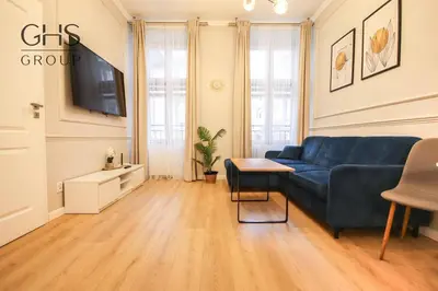 a living room with a blue couch and a tv at Elegancki apartament w centrum miasta-Kazimierz in Kraków