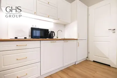 a kitchen with white cabinets and a microwave at Elegancki apartament w centrum miasta-Kazimierz in Kraków