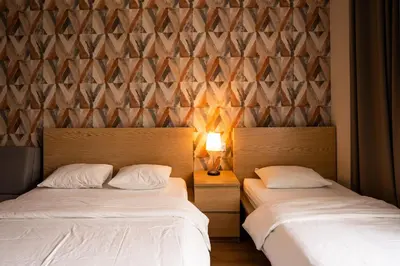 a bedroom with two beds and a wall with triangles at Pokoje na Różanej Zator - 2 km od Energylandii in Zator