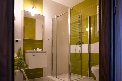 a bathroom with a shower with green and white tiles at Pokoje na Różanej Zator - 2 km od Energylandii in Zator