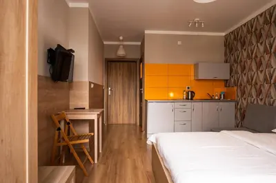 a bedroom with a bed and a desk and a kitchen at Pokoje na Różanej Zator - 2 km od Energylandii in Zator