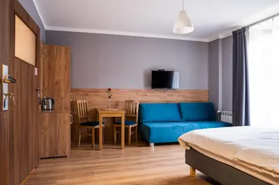 a bedroom with a blue couch and a table at Pokoje na Różanej Zator - 2 km od Energylandii in Zator