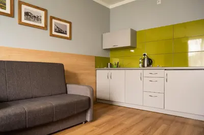 a living room with a couch and a kitchen at Pokoje na Różanej Zator - 2 km od Energylandii in Zator