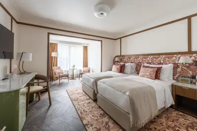 a hotel room with two beds and a living room at Stradom House, Autograph Collection in Kraków