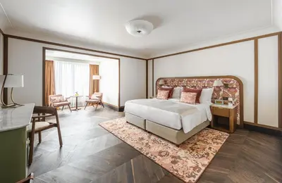 a bedroom with a large bed and a living room at Stradom House, Autograph Collection in Kraków