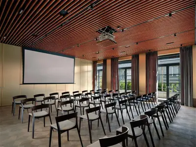 a conference room with chairs and a projection screen at Stradom House, Autograph Collection in Kraków