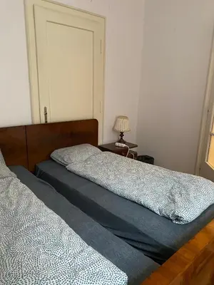 a bedroom with two beds and a table with a lamp at Vintage Rooms in Old Town in Kraków