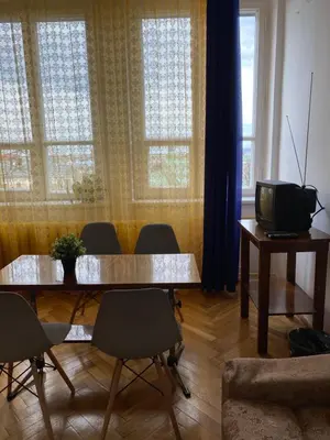 a living room with two tables and a television at Vintage Rooms in Old Town in Kraków