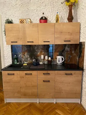 a kitchen with wooden cabinets and a counter top at Vintage Rooms in Old Town in Kraków