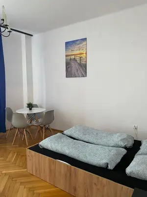 a bedroom with a bed and a table with chairs at Vintage Rooms in Old Town in Kraków