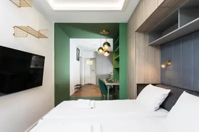 a bedroom with a white bed and a green wall at Verdant Oasis - Old Town Studio - by Upstairs in Kraków