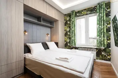 a bedroom with a large white bed and a window at Verdant Oasis - Old Town Studio - by Upstairs in Kraków