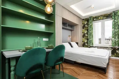a bedroom with a bed and two green chairs at Verdant Oasis - Old Town Studio - by Upstairs in Kraków