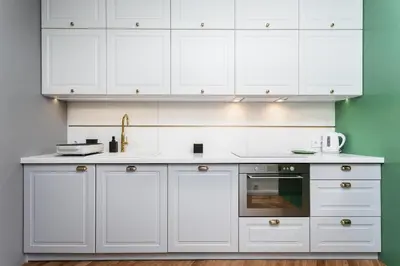 a white kitchen with white cabinets and a sink at Verdant Oasis - Old Town Studio - by Upstairs in Kraków