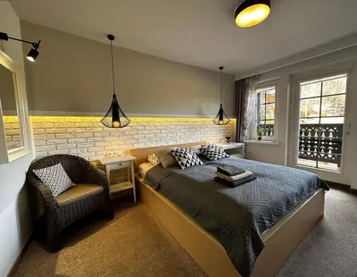 a bedroom with a bed and a chair at Willa Pod Bocianem in Ojców