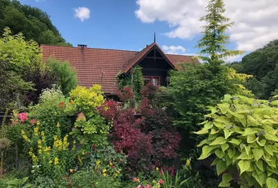 a garden in front of a house with flowers at Willa Pod Bocianem in Ojców