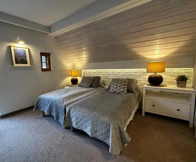 a bedroom with a bed and two lamps and a brick wall at Willa Pod Bocianem in Ojców