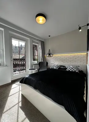 a bedroom with a large bed in a room with windows at Willa Pod Bocianem in Ojców