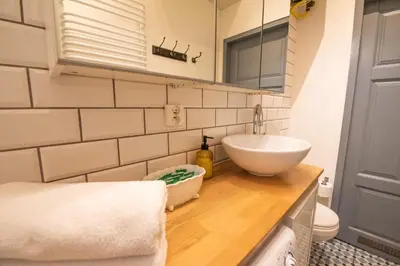 a bedroom with two beds and a yellow chair at Opera Apartments in Kraków