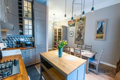 a blue kitchen with a vase of flowers on a table at Opera Apartments in Kraków